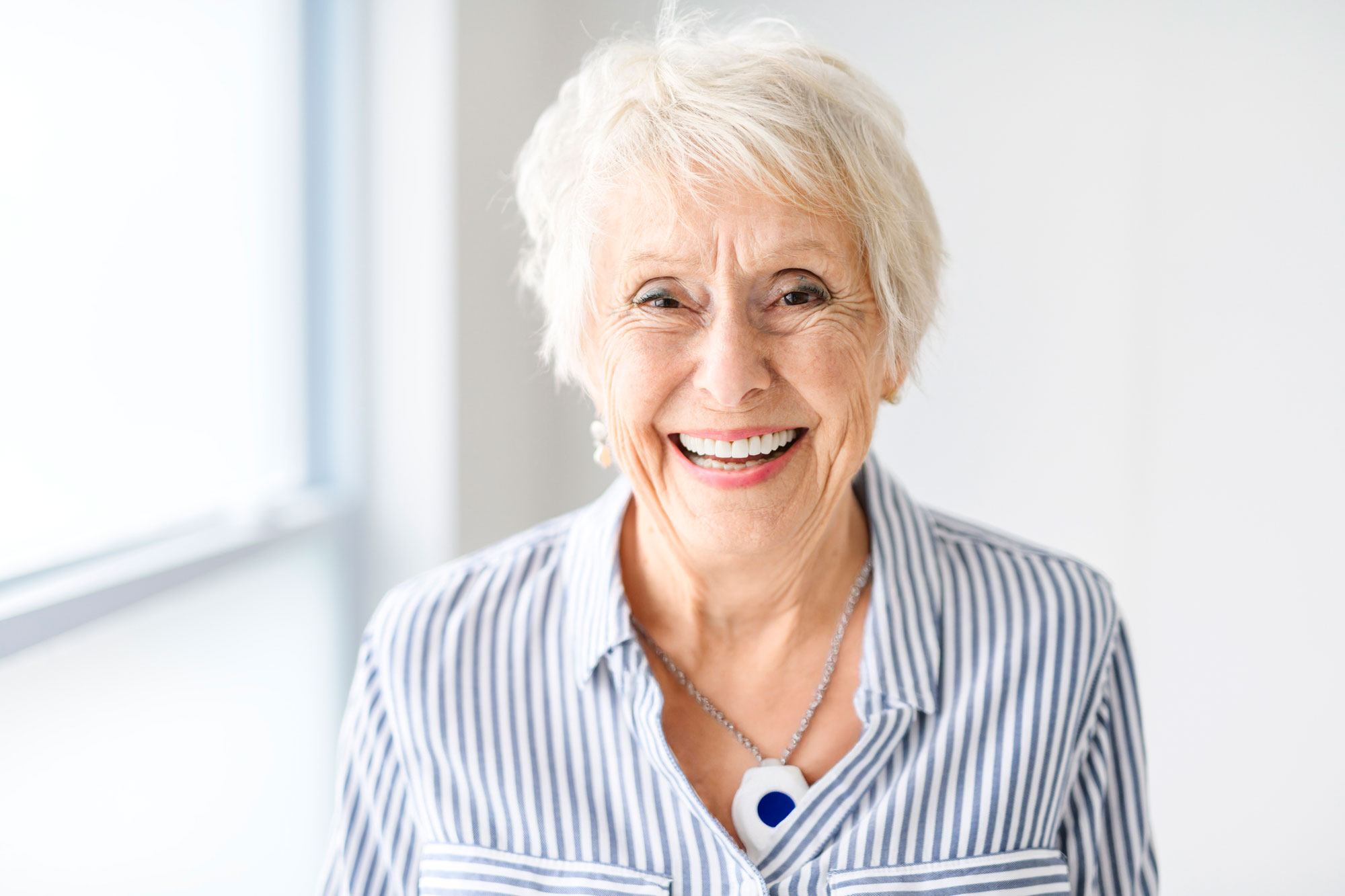 Senior woman wearing a VitalCall pendant in her garden